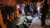 People gather around remains of a military plane at the site where it crashed into a residential building in the city of Irkutsk, Russia, October 23, 2022, photo by Stringer/Reuters