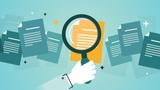 Image of a hand magnifying a document, by Julien Eichinger/Adobe Stock