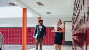 Two teachers walking in a school hallway, photo by SolStock/Getty Images
