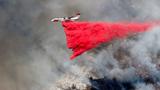 A plane drops fire retardant on the Palisades fire in Mandeville Canyon in Los Angeles, California, January 11, 2025, photo by Shannon Stapleton/Reuters